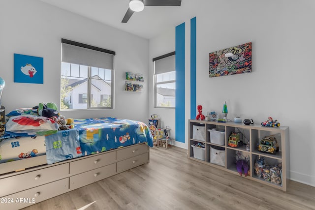 bedroom featuring multiple windows, ceiling fan, and light hardwood / wood-style flooring