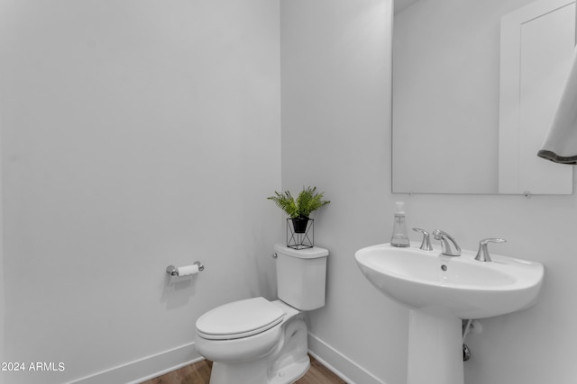 bathroom with hardwood / wood-style flooring and toilet