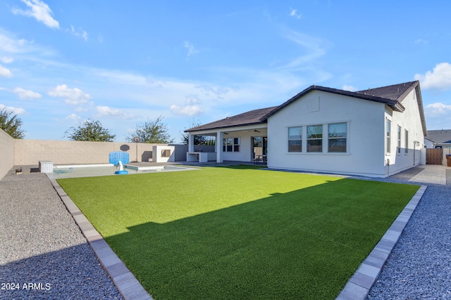 back of house with a yard and a patio