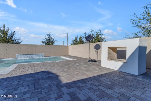 view of swimming pool with pool water feature and a patio