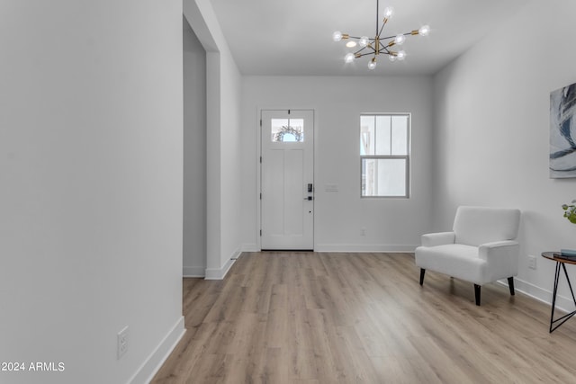 entrance foyer with a notable chandelier and light hardwood / wood-style flooring