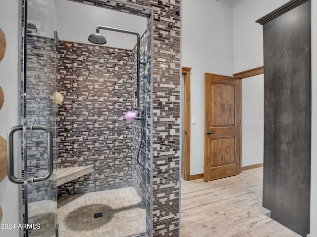 bathroom with hardwood / wood-style floors and an enclosed shower