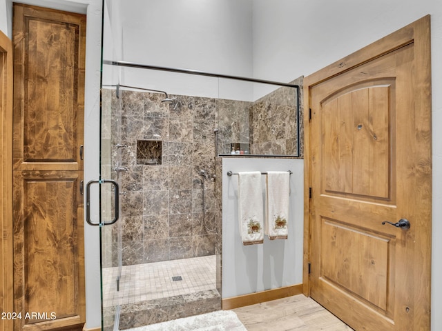 bathroom featuring wood-type flooring and a shower with door