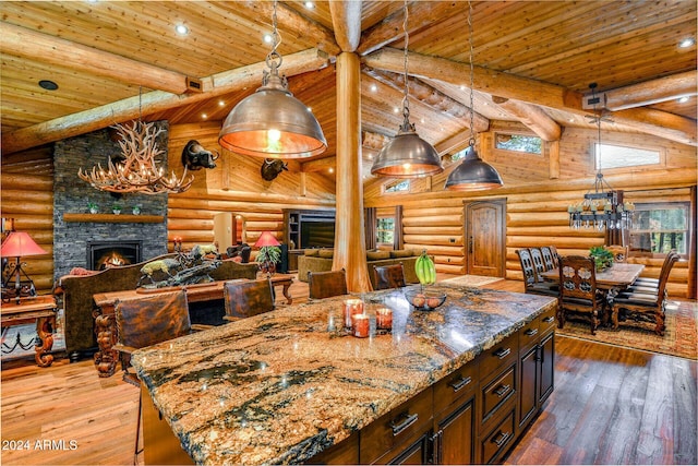 kitchen with rustic walls, a center island, hardwood / wood-style floors, and a fireplace