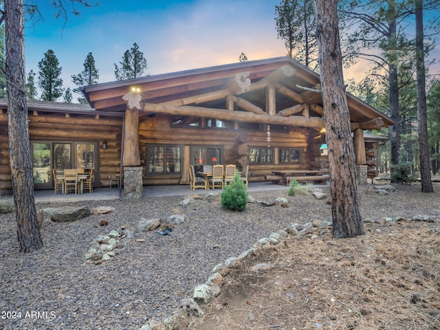 back house at dusk featuring french doors and a patio area