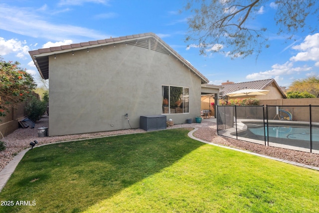 rear view of house featuring a fenced in pool and a lawn