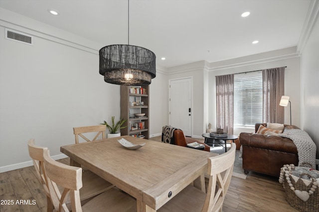 dining room with an inviting chandelier and light hardwood / wood-style flooring