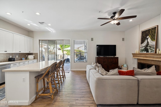 living room with ceiling fan and light wood-type flooring