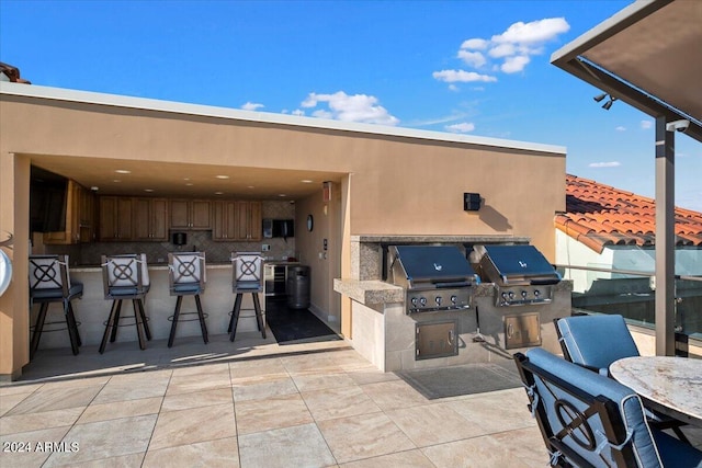 view of patio / terrace with a grill, an outdoor kitchen, and exterior bar