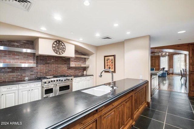 kitchen with dark hardwood / wood-style floors, custom range hood, double oven range, sink, and white cabinetry