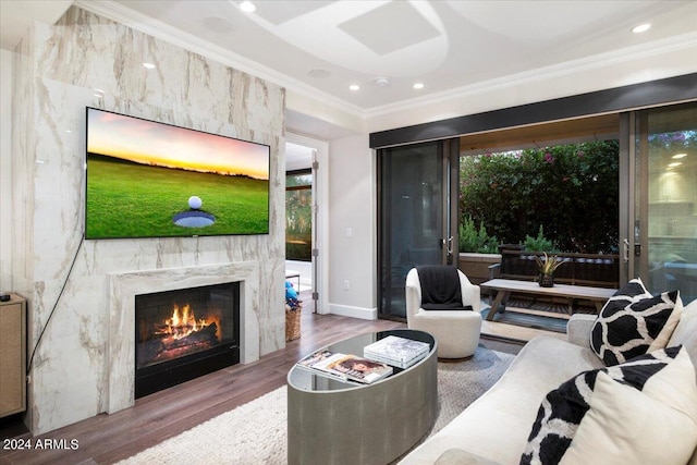 living room with a high end fireplace, ornamental molding, and hardwood / wood-style floors