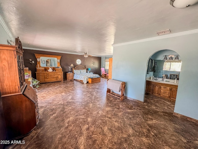 bedroom featuring crown molding, ensuite bathroom, baseboards, and arched walkways