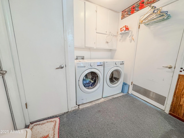 clothes washing area with washer and dryer and cabinet space
