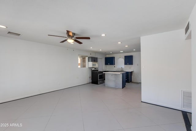 6040 N 31st Dr, Phoenix, AZ 85017 - kitchen featuring stainless steel range with gas cooktop, white microwave, light countertops, a ceiling fan, and recessed lighting