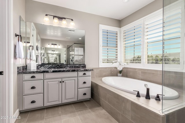 bathroom featuring vanity, shower with separate bathtub, and tile patterned floors