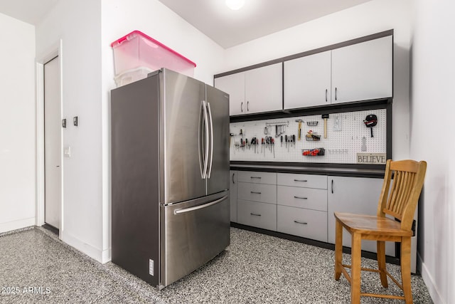 kitchen featuring stainless steel fridge and white cabinets