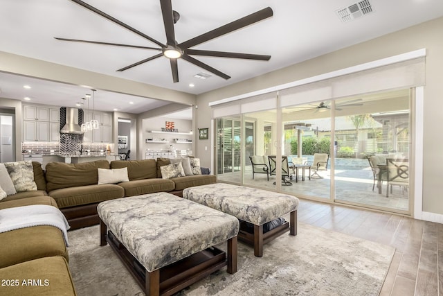 living room with bar, hardwood / wood-style flooring, and ceiling fan