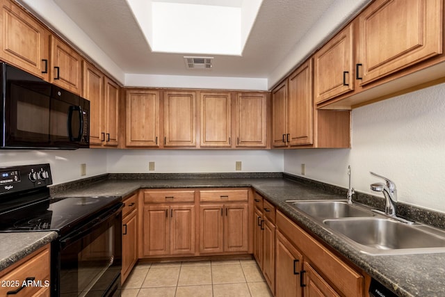 3434 E Baseline Rd Unit 216, Phoenix, AZ 85042 - kitchen with black appliances, a sink, brown cabinetry, and dark countertops