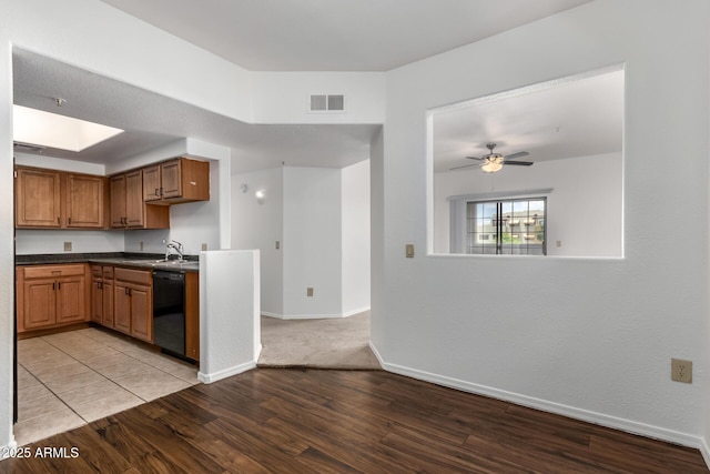 3434 E Baseline Rd Unit 216, Phoenix, AZ 85042 - kitchen featuring dishwasher, light wood-style floors, a sink, dark countertops, and baseboards