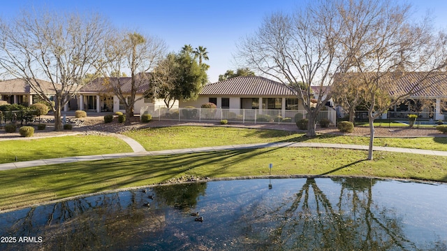 back of house featuring a yard and a water view