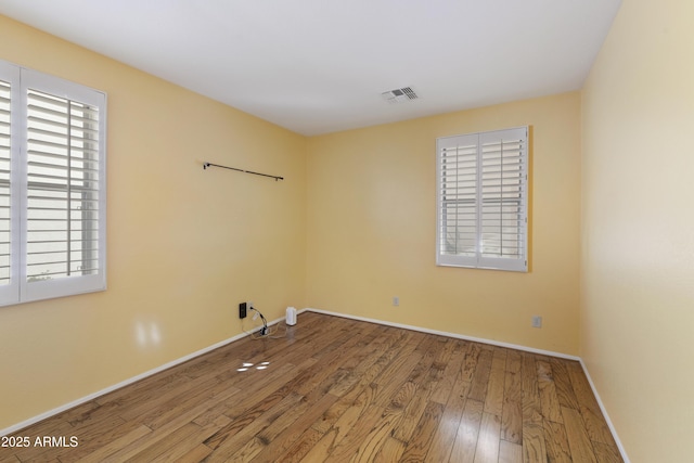 spare room with plenty of natural light and wood-type flooring