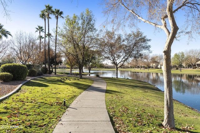 view of home's community with a water view and a yard