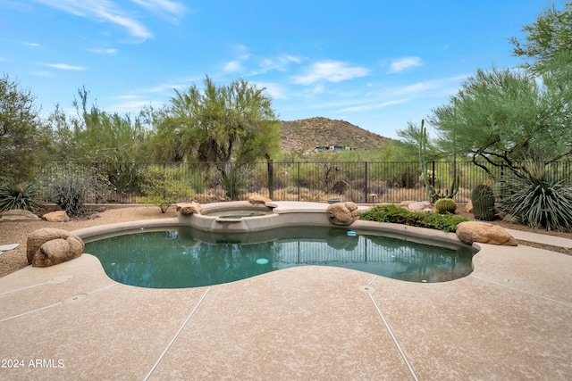 view of pool with a mountain view, a patio area, and an in ground hot tub