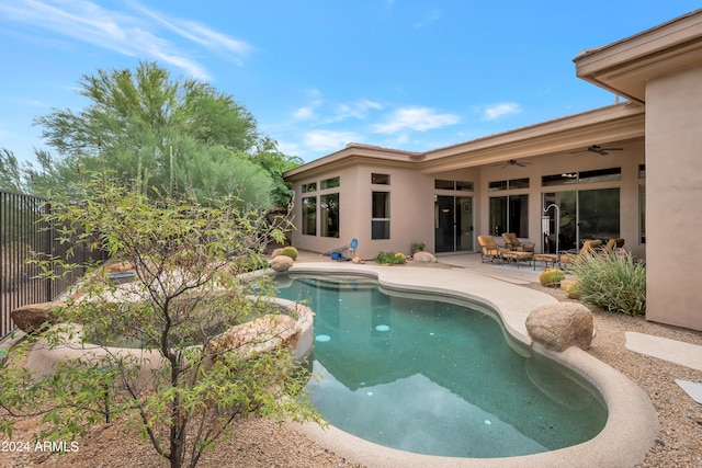 view of swimming pool with ceiling fan and a patio