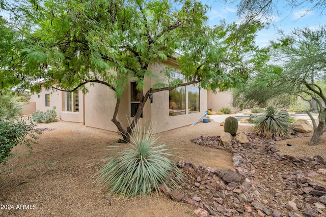 back of property featuring a patio area and stucco siding