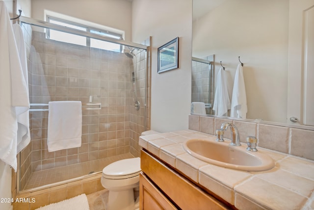 bathroom featuring an enclosed shower, toilet, and vanity