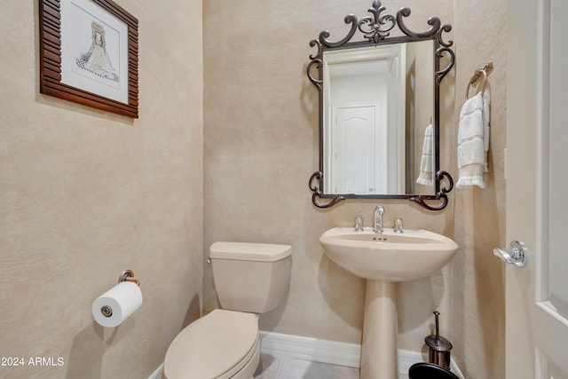 half bathroom with toilet and baseboards