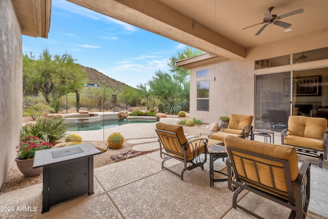 view of patio featuring an outdoor living space, a mountain view, ceiling fan, and a fenced in pool