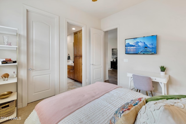 bedroom with light carpet and connected bathroom