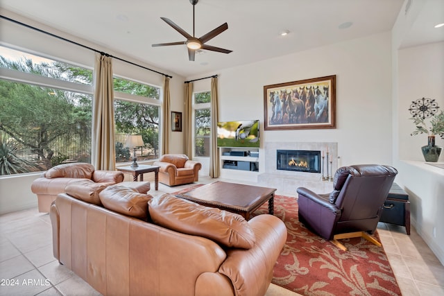 tiled living room with ceiling fan and a tile fireplace