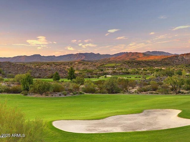 view of home's community with a lawn, golf course view, and a mountain view