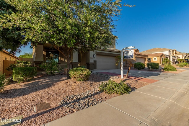 6632 W Saguaro Park Ln, Glendale, AZ 85310 - view of property hidden behind natural elements featuring stucco siding, concrete driveway, and an attached garage