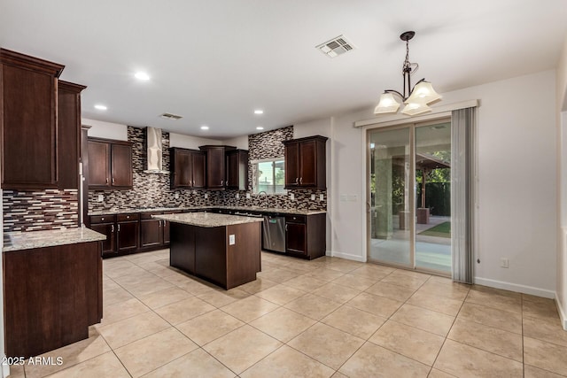 6632 W Saguaro Park Ln, Glendale, AZ 85310 - kitchen featuring backsplash, wall chimney exhaust hood, dark brown cabinets, light tile patterned flooring, and a center island