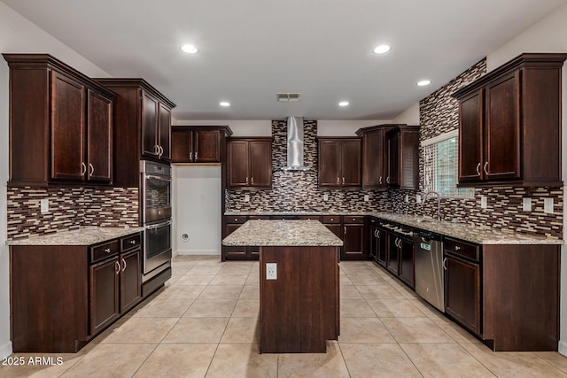 6632 W Saguaro Park Ln, Glendale, AZ 85310 - kitchen with wall chimney exhaust hood, stainless steel appliances, decorative backsplash, a kitchen island, and dark brown cabinetry