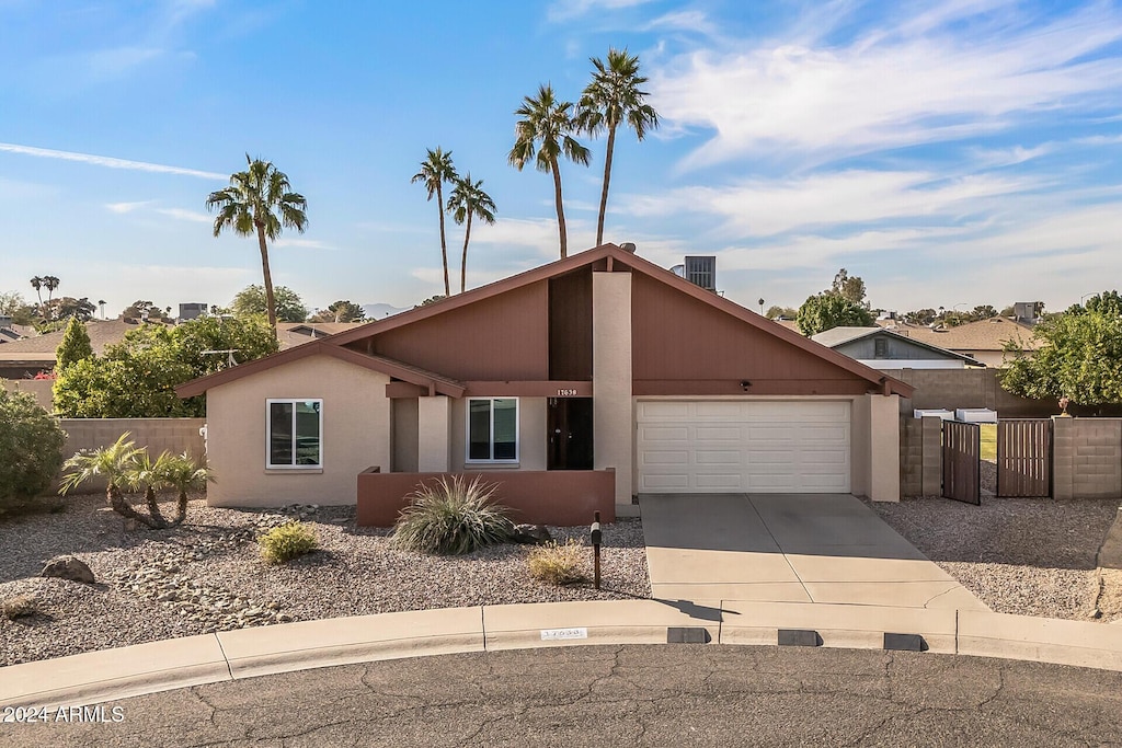 ranch-style house with a garage and central AC unit