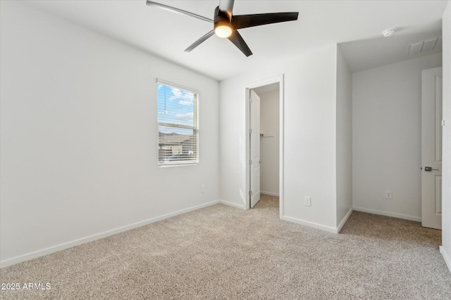 unfurnished bedroom featuring a ceiling fan, carpet, a spacious closet, and baseboards