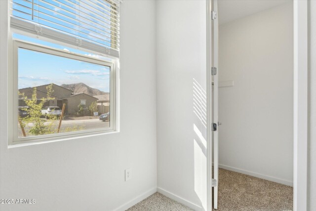 carpeted empty room featuring a healthy amount of sunlight and baseboards