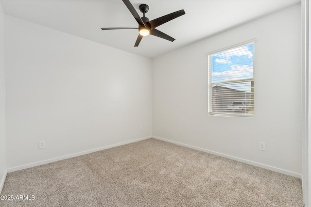 carpeted empty room featuring a ceiling fan and baseboards