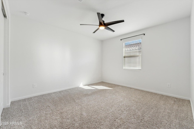 empty room with carpet flooring, a ceiling fan, and baseboards