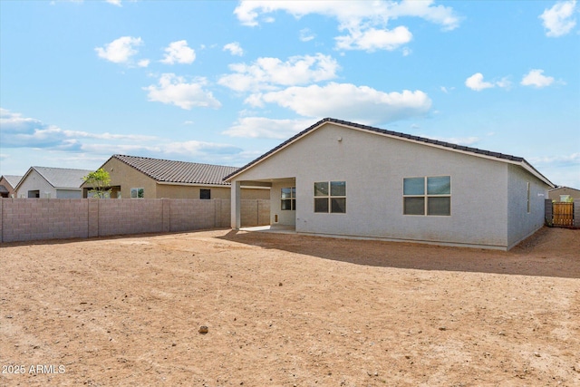 rear view of property featuring a patio area, a fenced backyard, and stucco siding