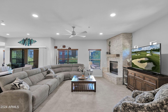 living area with recessed lighting, light colored carpet, a ceiling fan, and a stone fireplace