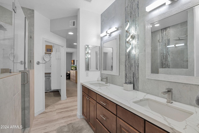 bathroom featuring double vanity, a sink, visible vents, and a shower stall