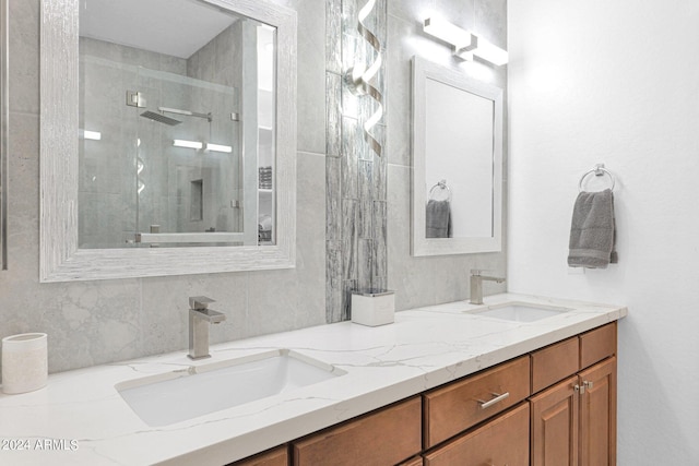 full bath with tiled shower, a sink, and double vanity