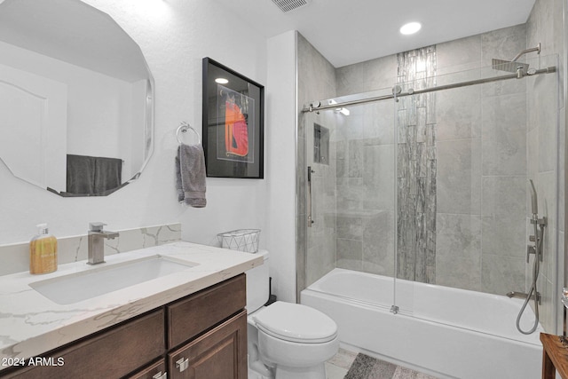 bathroom with shower / bath combination with glass door, vanity, and toilet