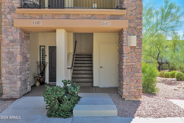 entrance to property with stone siding and stucco siding