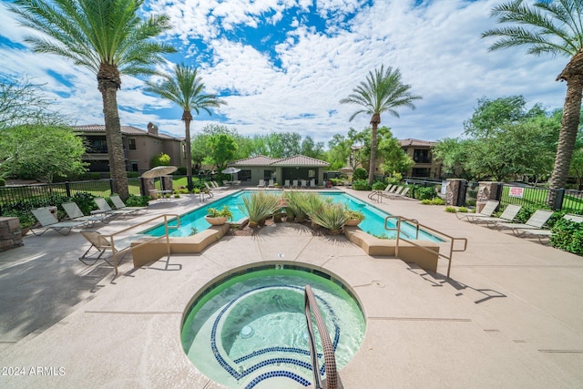 pool featuring a patio area, fence, and a hot tub